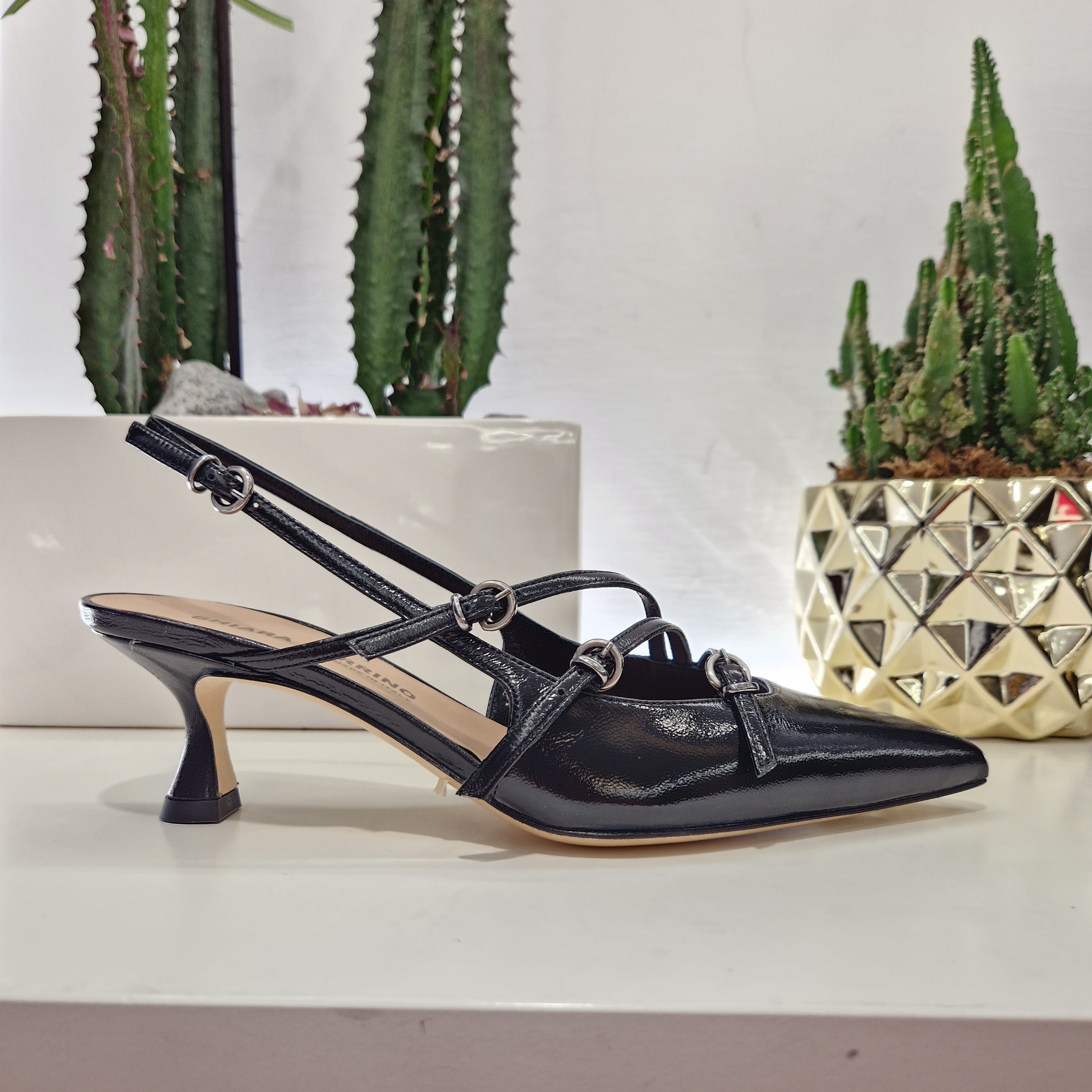 Patent leather shoe with black straps