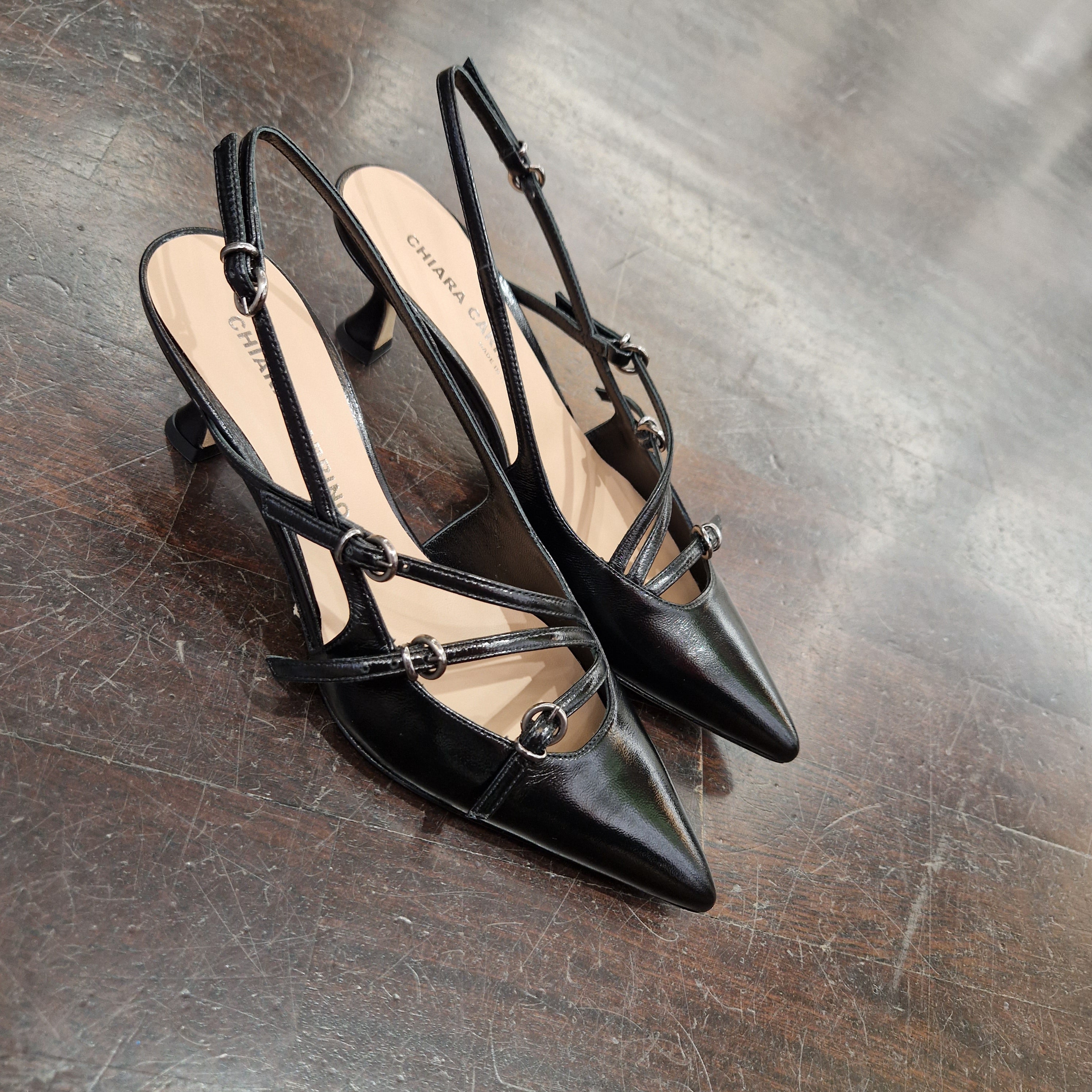 Patent leather shoe with black straps