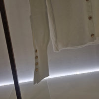 Maglia cardigan panna con bottoncini oro